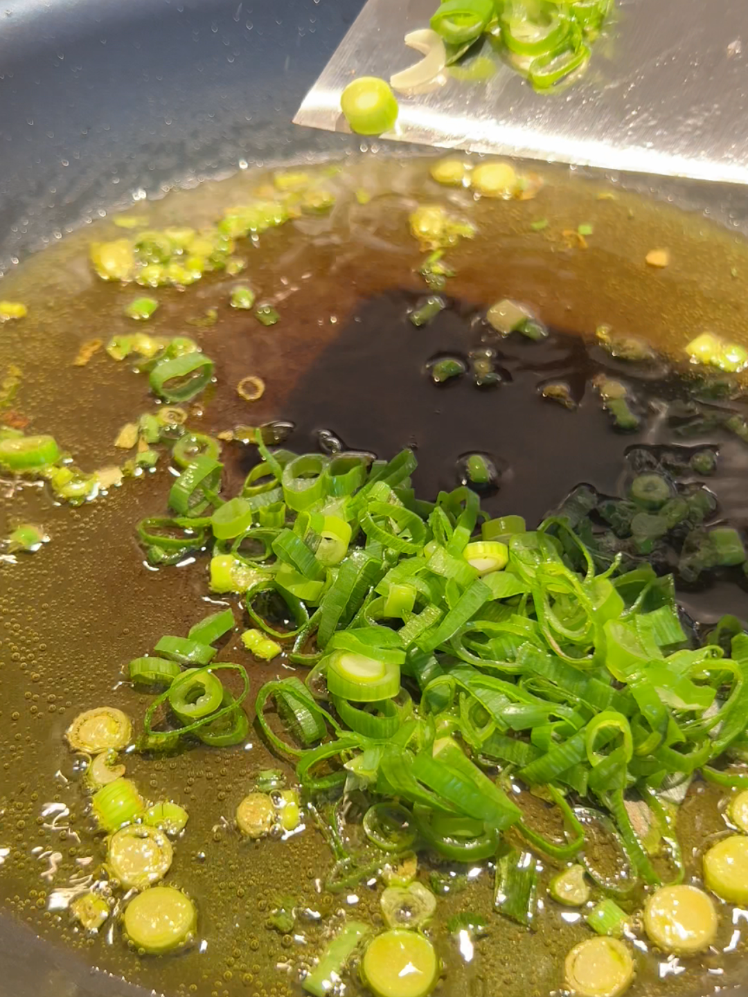 putting scallions in oil